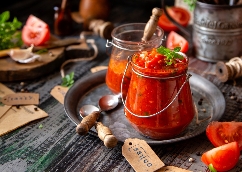 A view of marinara sauce canned with a basil on top