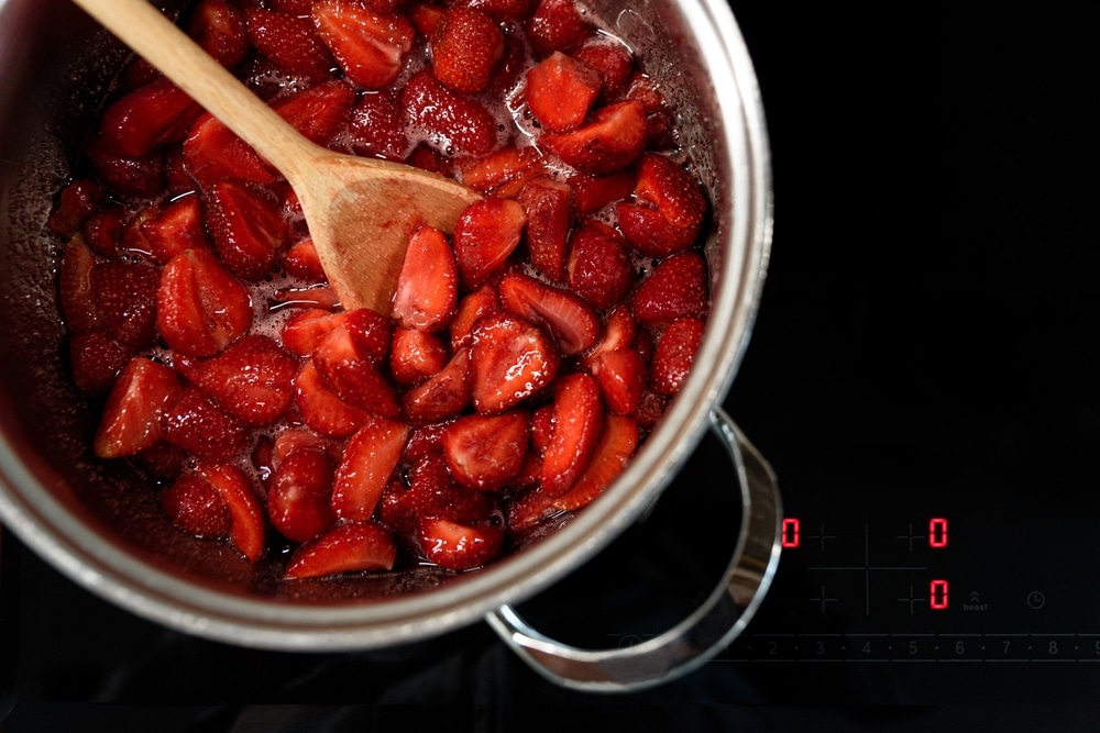 An overhead view of a pot with strawberry jam being made