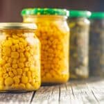 Canned Sweet Corn In Jar On A Wooden Table