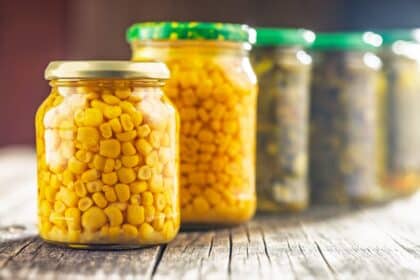 Canned Sweet Corn In Jar On A Wooden Table