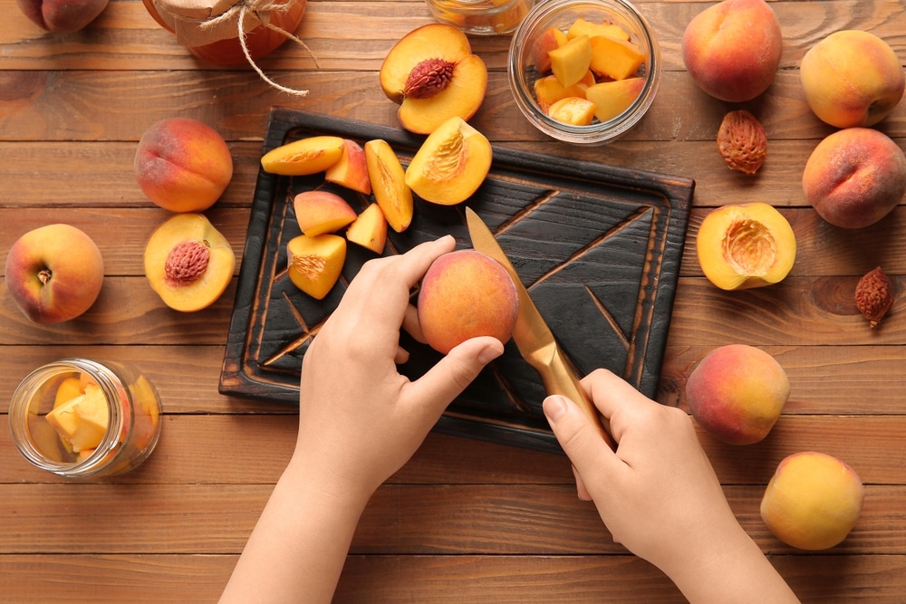 Woman Preparing Sweet Peach Jam On Wooden Background