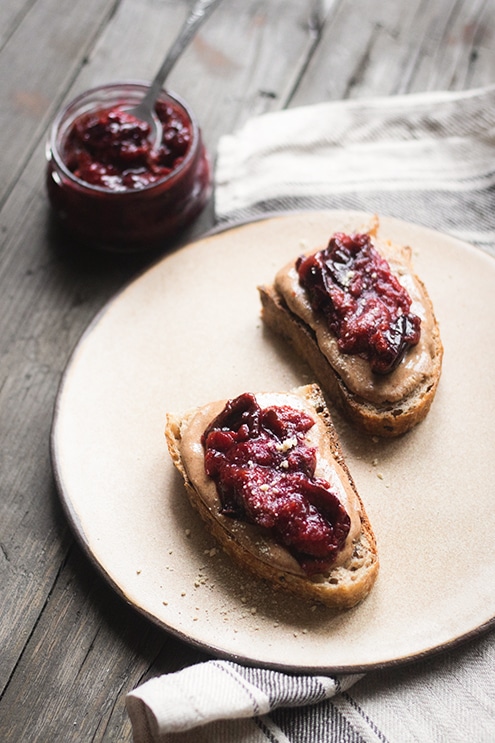 A view of a chunky plum jam on two toasts inisde a plate