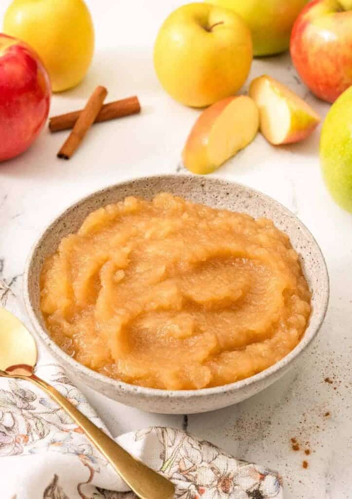 applesauce in a bowl apples placed on the side