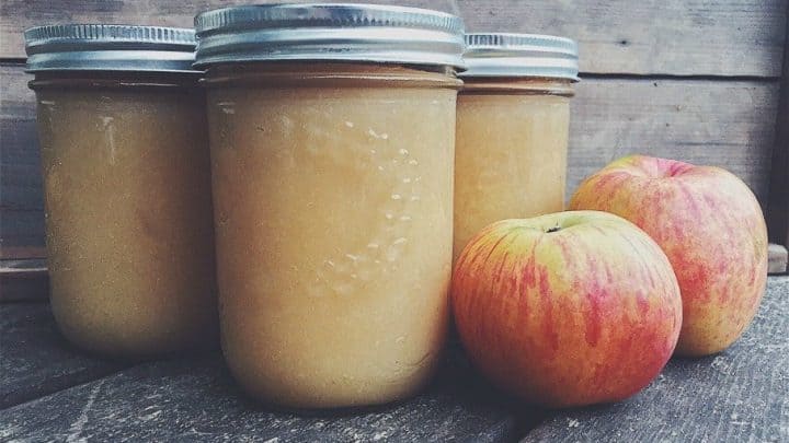 jars of apple sauce with apples