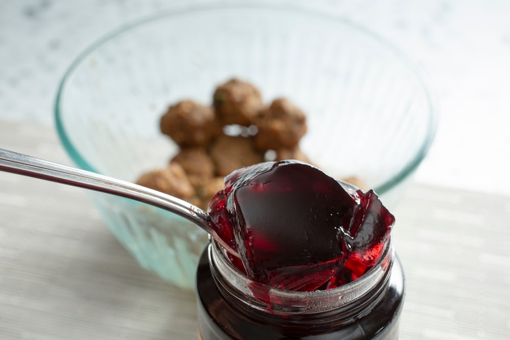 A View Of A Spoon Scooping Some Grape Jelly A