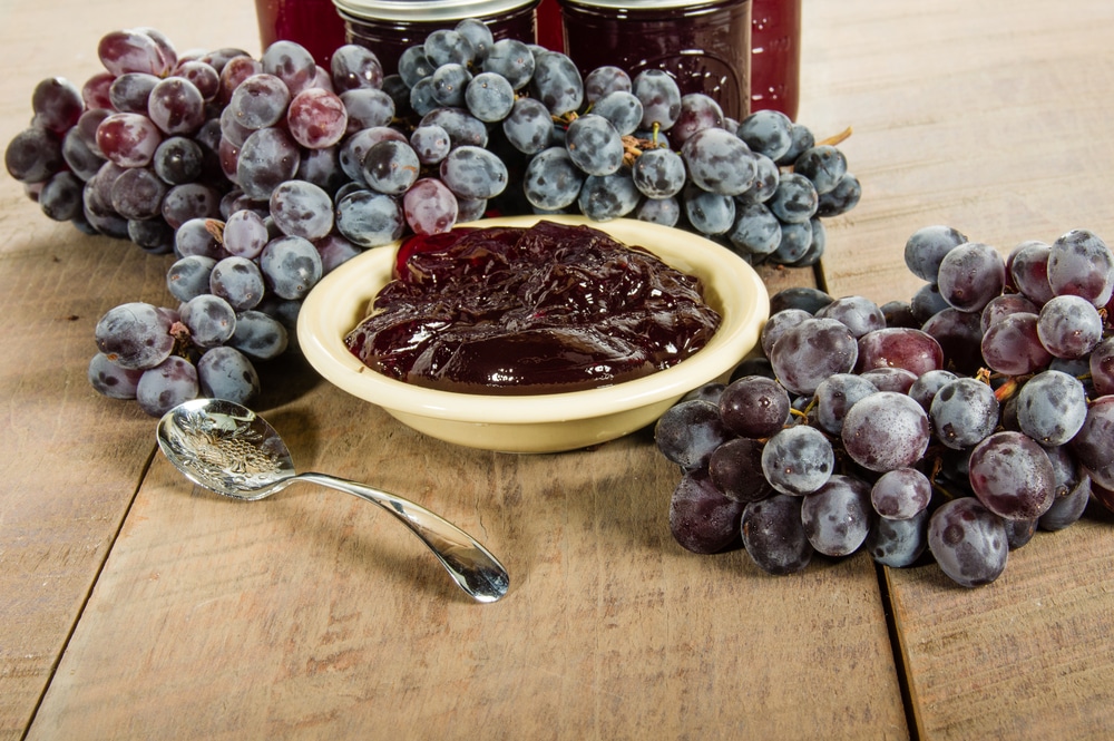 Bowl Of Fresh Grape Jelly With Grapes And Jars