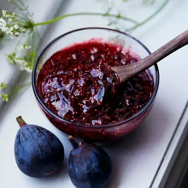 a bowl full of fig jam along with fresh figs