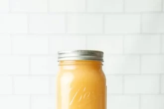 jars of apple sauce placxed on a cloth with an apple