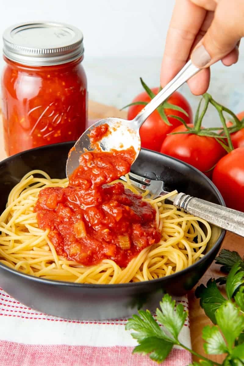 spooning spaghetti sauce on pasta