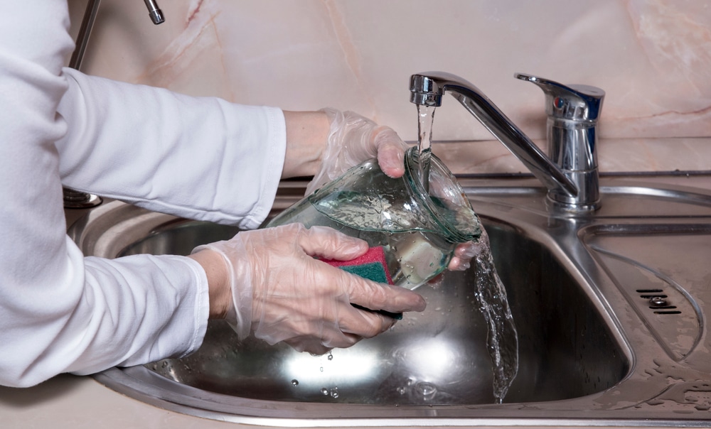 Woman’s Hands With Gloves Washing Dish With Fresh Water At