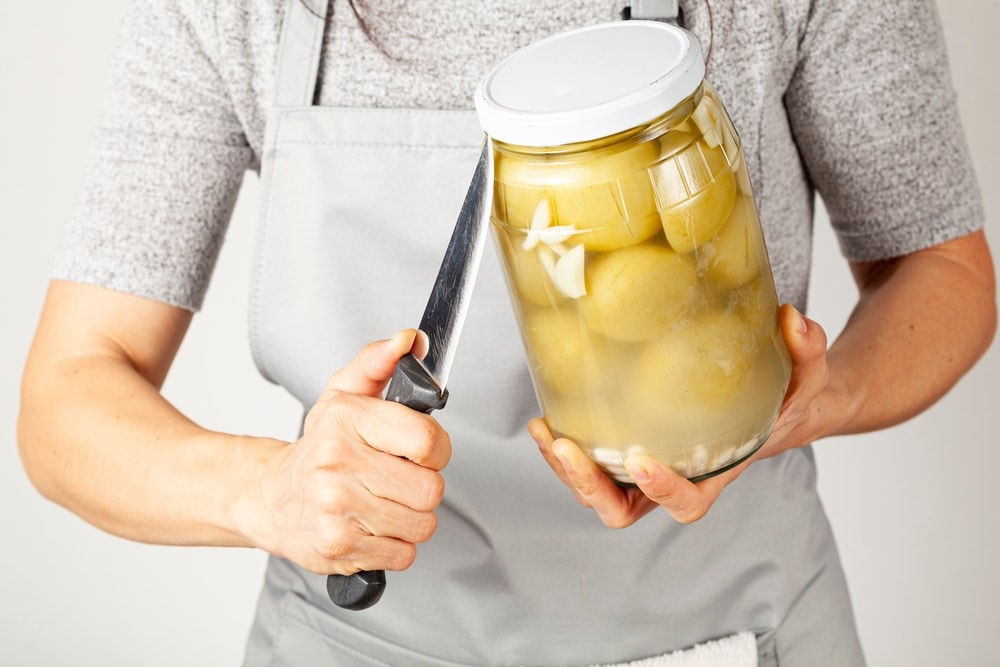 A Caucasian Woman Wearing Apron Is Trying To Open A