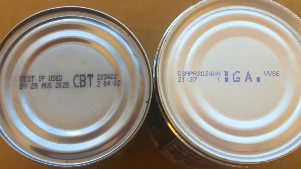An overhead view of two cans with expiry date on them An overhead view of two cans with expiry date on them